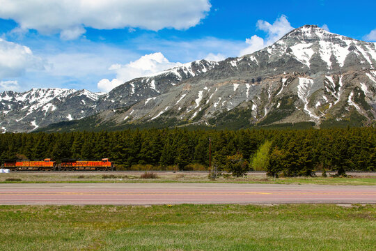 Two BNSF locomotives pulling a train across Marias Pass below Little Dog Mountain in Montana USA.