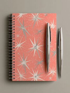 Notebook cover displays a mid-century modern pattern with starburst and boomerang shapes in coral and grey. Stylish design reflects 1950s aesthetics.