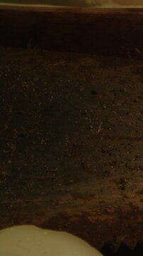 Vertical detailed macro dolly of a rusty and dirty saw lying at the base of an occult altar. Bloody ropes get revealed and show a macabre ritual.