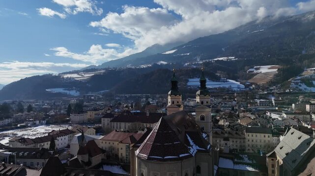 Cinematic Upward Drone Reveal from Stream to Cathedral and Bressanone with Alps, South Tyrol, Italy
