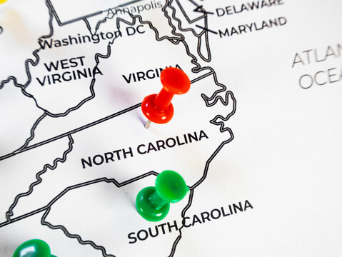 Macro close-up of a southeastern US map focusing on North Carolina and South Carolina with red and green push pins. Perfect for regional logistics, target marketing, and travel route tracking.