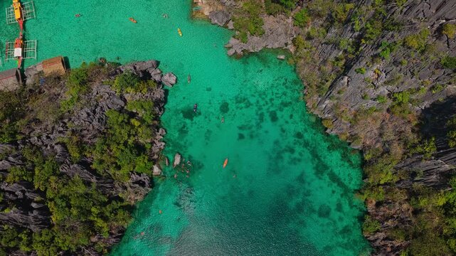 Aerial top down view of crystal clear emerald green lagoon water and limestone reefs in Coron, Palawan, Philippines.