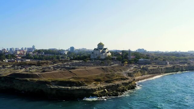 Sevastopol, Crimea. Saint Vladimir Cathedral, gilded dome and white neo-Byzantine walls above ancient stone ruins of Chersonesus Taurica, Drone footage along the Black Sea coast. Drone footage, Point