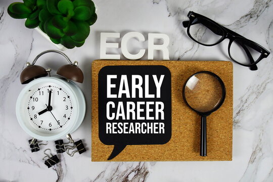 ECR - Early Career Researcher acronym with alarm clock and magnifying glass, business concept background