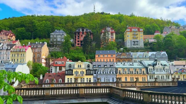 The colorful buildings and lush trees in Karlovy Vary, Czech Republic. This location showcases vibrant architecture and a lively atmosphere in the daytime.