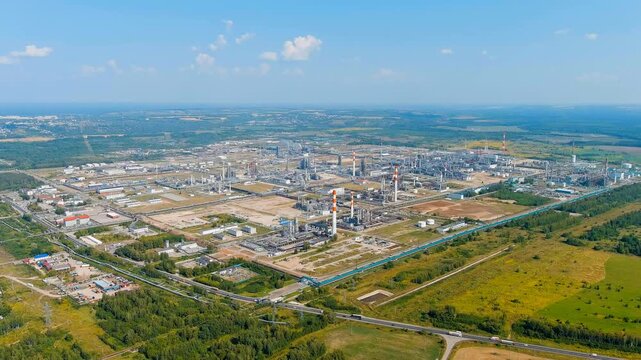 Kstovo, Nizhny Novgorod region, Russia. Sprawling oil refinery complex with tall chimneys and distillation towers, Drone footage over the M7 Volga highway under clear summer sky. Drone footage