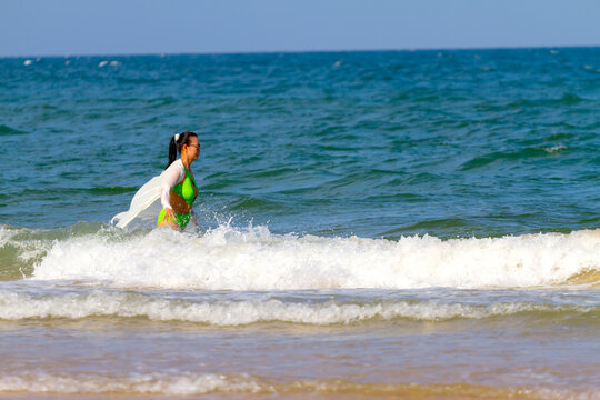 Woman in green swimsuit play wave