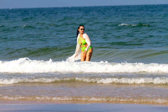 Woman in green swimsuit play wave