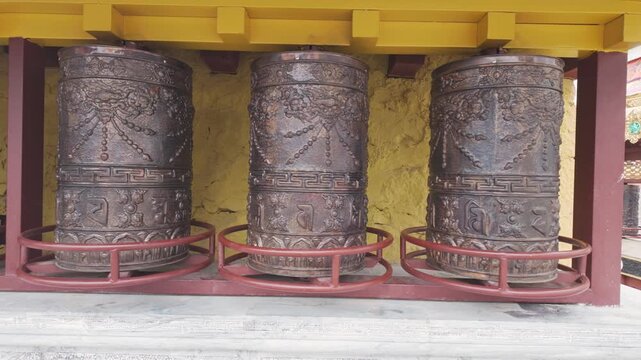 Prayer wheels spinning in courtyard of Tibetan Buddhist Monastery in China