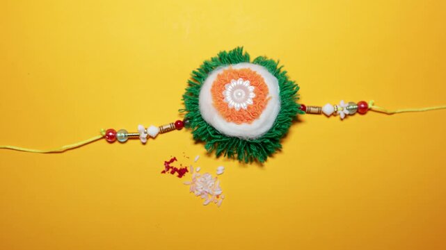 traditional raksha bandhan rakhi isolated with rice grains and kumkum powder