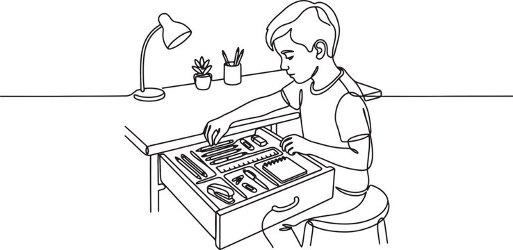 boy sitting at desk with open drawer full of office supplies