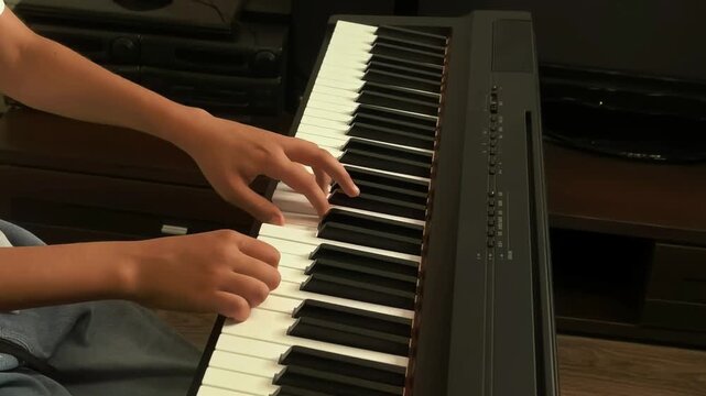 Close up fingers playing piano keyboard, music performance and creative hobby concept.