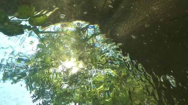 POV underwater shot below a freshwater lake surface, showing a spinning vortex, distorted forest reflections and a dramatic drowning simulation.