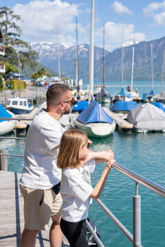 Man with daughter enjoy a view of a beautiful lake in Switzerland, Thun lake, Spiez