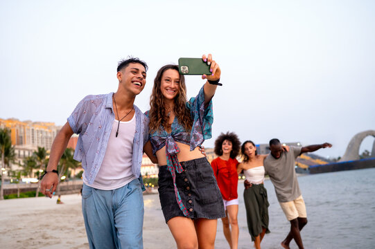Friends enjoying a fun travel adventure on a tropical beach at sunset, making lasting memories