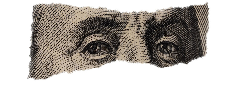 Close-up of Benjamin Franklin's Eyes on Torn Dollar Bill
