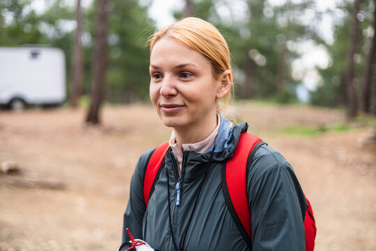Young blonde woman smiling while hiking in forest