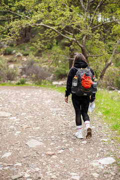 Young woman hiking with a backpack on a trail