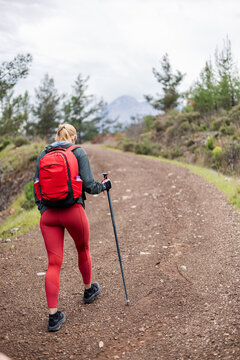 Blonde woman hiking on a gravel mountain path