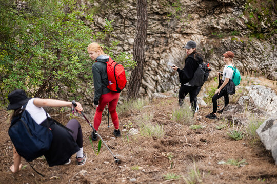 Woman stumbles on trail while hiking with friends