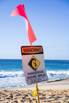 Warning sign for dangerous shore break at a beach in Hawaii