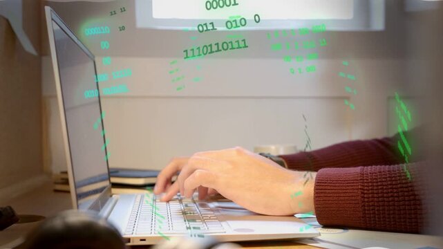Man typing at desk generating green alphanumeric overlay in technology demo, code flowing inward