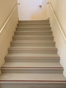 The stairwell shows safety handrails for an emergency exit in a nursing home building in Canada. The stairs lead to an exit door.