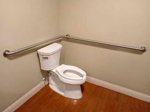 Safety bars installed next to toilet in healthcare bathroom for seniors