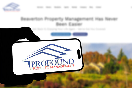 Kiel, Germany - 05-20-2026: Smartphone displaying the real estate company Profound Properties app in the App Store in a workspace environment with laptop and notebook