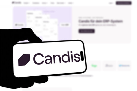 Kiel, Germany - 05-20-2026: Smartphone displaying the German accounting automation software company Candis app in the App Store in a workspace environment with laptop and notebook