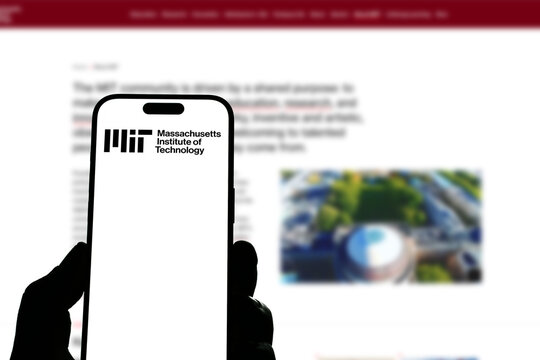 Kiel, Germany - 05-20-2026: Smartphone displaying the US university Massachusetts Institute of Technology app in the App Store in a workspace environment with laptop and notebook