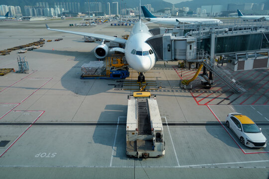 Big commercial airplane is connected via a hose for boarding passengers, and ready for tow push back truck preparing for the flight, straight view