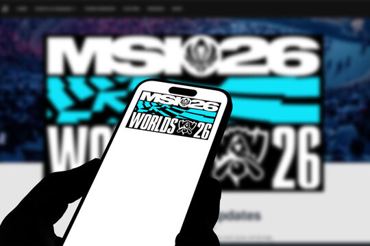 Kiel, Germany - 05-20-2026: Smartphone displaying the international esports tournament League of Legends MSI 26 app in the App Store in a workspace environment with laptop and notebook