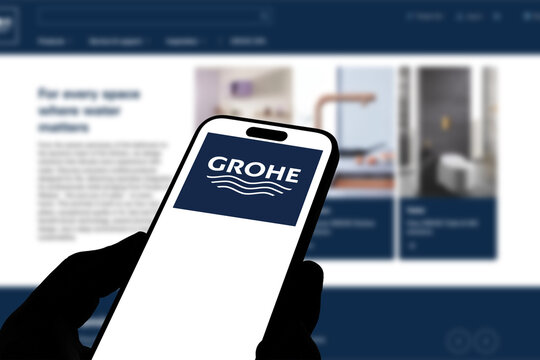 Kiel, Germany - 05-20-2026: Smartphone displaying the German sanitary fittings manufacturer GROHE app in the App Store in a workspace environment with laptop and notebook