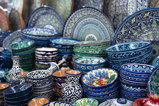 Traditional Uzbek hand-painted ceramics displayed at Siab bazaar in Samarkand. Colorful plates, bowls, and vases with intricate floral patterns. Ideal for travel, culture, and handicraft content.