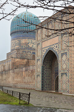 Bibi Khanum Mosque in Samarkand with its turquoise dome and intricate tilework facade. Historic Islamic architecture of Uzbekistan, ideal for travel and cultural publications.