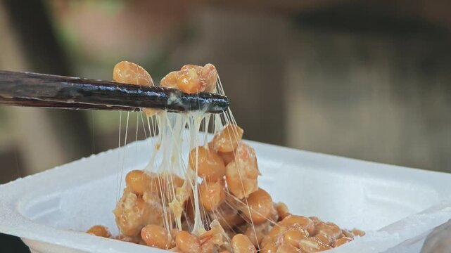 Japanese Natto lifted by chopstick.