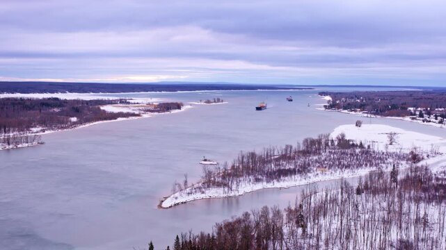 Cinematic drone footage of a freighter cruising toward Sault Ste. Marie and the Soo Locks