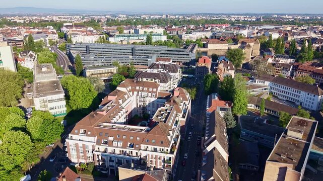 Distant backward panorama shot of covered Bassin Vauban sandstone dam bridge and Hotel d'Alsace building at residential Petite France area in Strasbourg, France