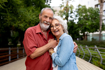 Fototapeta premium Happy senior couple embracing outdoors enjoying retirement life