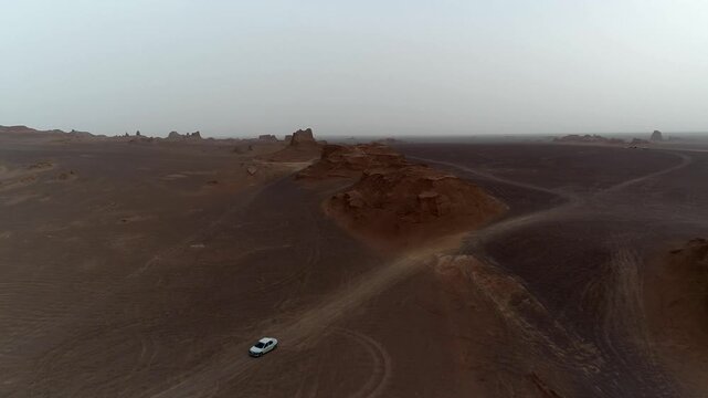 Single prominent yardang tower rises from desert floor with wind-eroded sides under clear sky creating isolated natural rock formation scene ideal for geology and desert landscape stock video