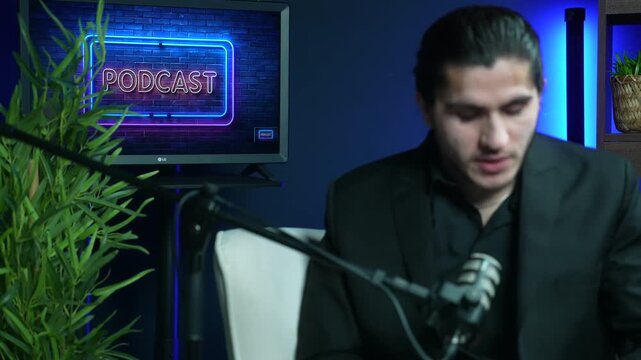 Young male host speaking actively during a video recording in a professional podcast studio