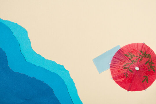 Abstract Ocean Waves Made with Layered Blue Paper and Decorative Parasols. Beach, summer.