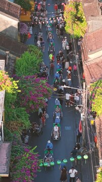 Aerial panoramic view of Hoi An city, Da Nang province, Vietnam. Pedicabs carrying tourists for sightseeing in the old town, UNESCO world heritage. One of the most travel popular touristic destination
