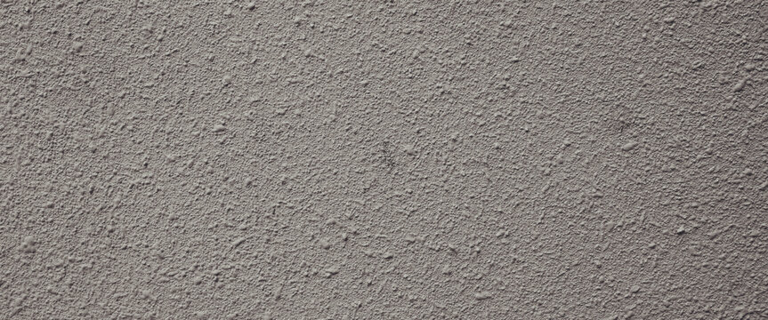 Gray bumpy plaster wall suitable for background or texture in design projects. Adds neutral grainy texture to stone finish.