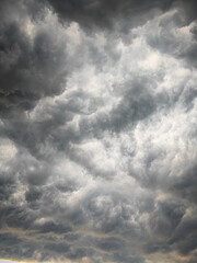 Fototapeta premium Storm clouds, A dramatic, high-contrast shot of black clouds that captures the turbulent and intense texture of a large storm front forming in a dark, gloomy sky.