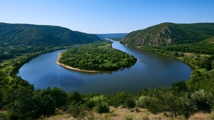 Fototapeta premium A winding river flows through a lush forested valley under clear midday sunlight creating a serene natural landscape