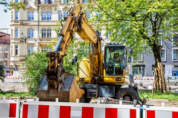 Yellow wheeled excavator working on a city street construction site ©  Tsvyk L.