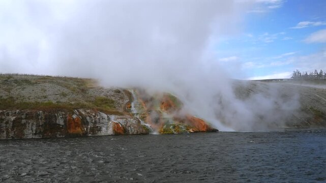 Grand Prismatic Spring largest hot springs steaming pool Mid Geyser Basin Firehole River Wyoming USA Yellowstone National Park nature landscape Midway Boardwalk trail sunny blue sky morning pan