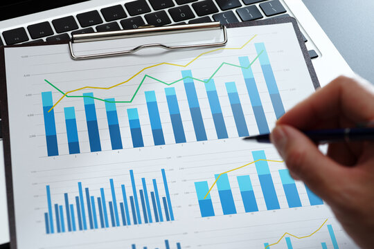 Business analysis reports with graphs. Statistical KPI performance data and financial results. Businessman reviewing plan and developing growth strategy on desk.